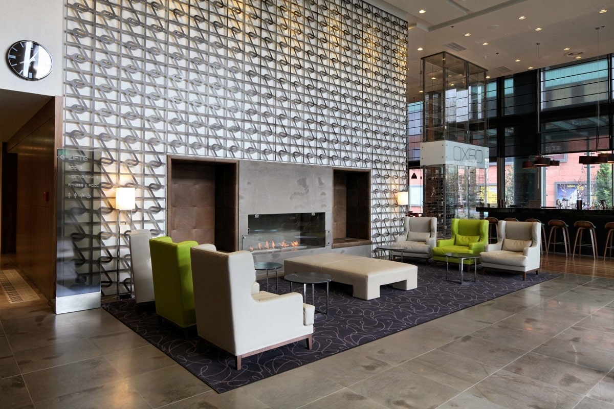 Hotel interior lobby with chairs and sofa near fireplace